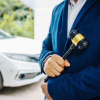 Lawyer holding a gavel with cars in the background, symbolizing DUI legal cases in Norfolk, Virginia. Understanding new DUI laws.